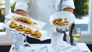 Private chef serving gourmet appetizers and fried dishes at a luxury villa dining setup | St. Barthélemy Villas